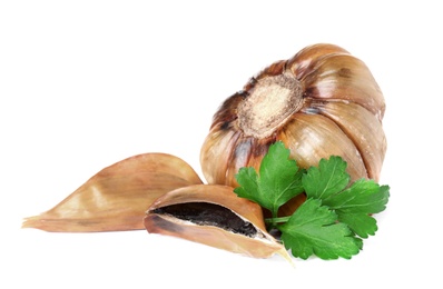 Aged black garlic with parsley on white background