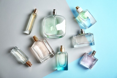 Perfume bottles on colorful background, flat lay