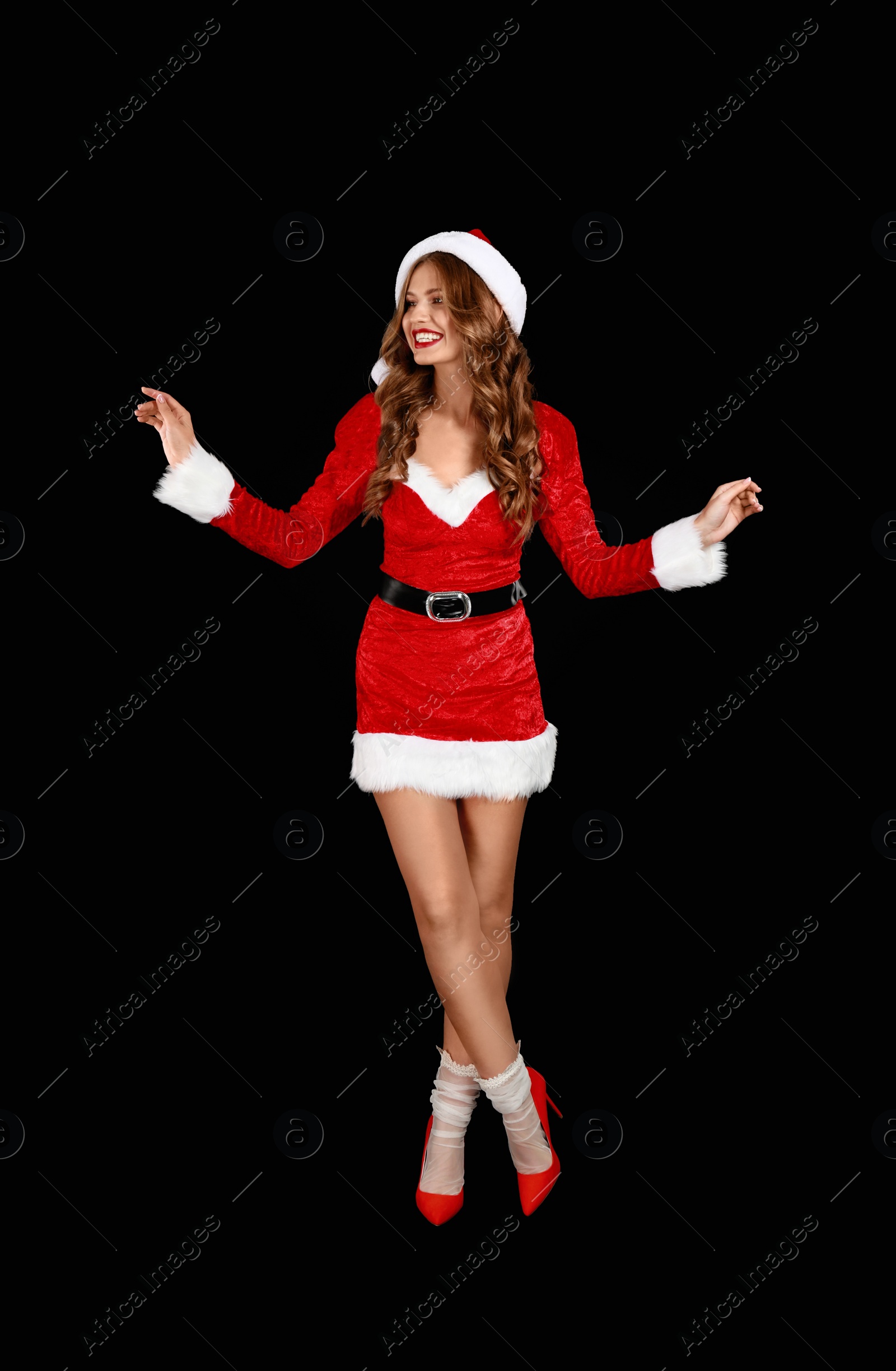 Photo of Beautiful Santa girl on black background. Christmas celebration