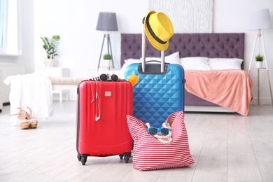 Photo of Large suitcases and bag packed for summer journey in room