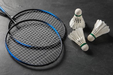 Photo of Feather badminton shuttlecocks and rackets on grey textured table
