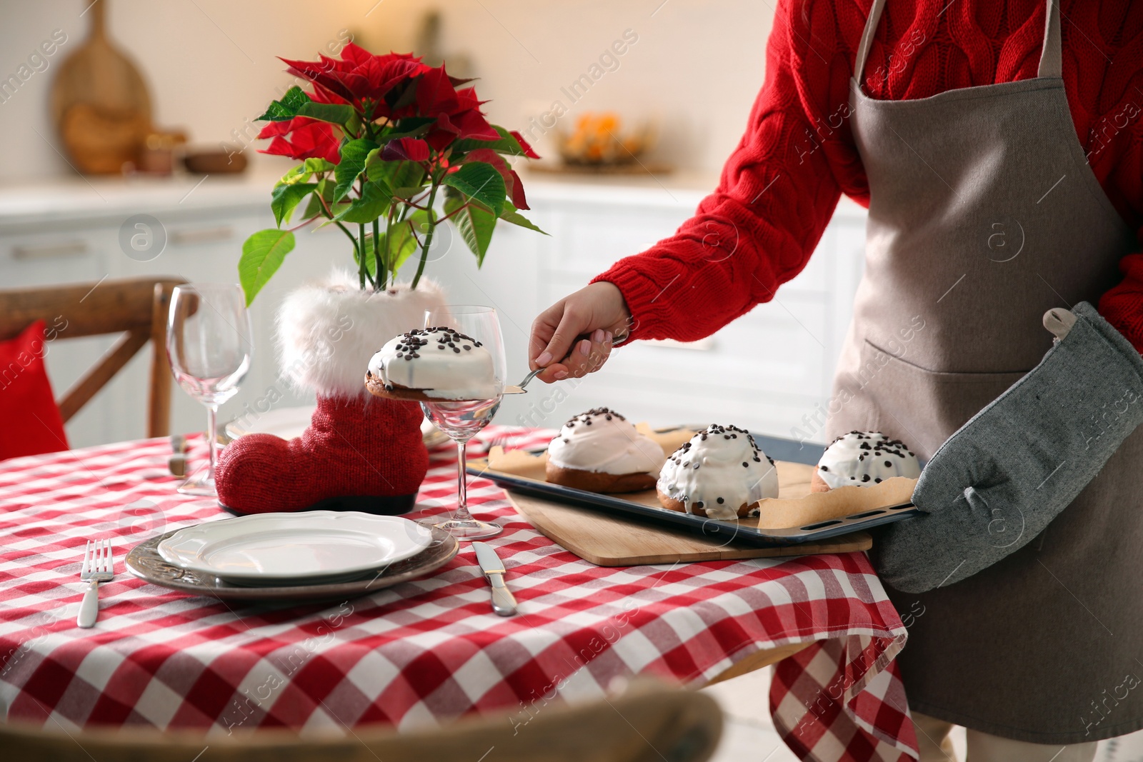 Photo of Woman with sweet buns for Christmas dinner in kitchen, closeup