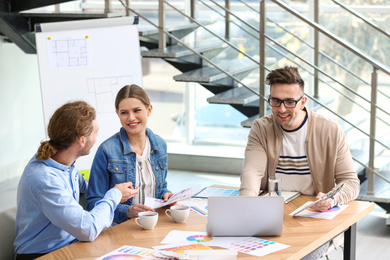 Photo of Interior designer consulting young couple in office