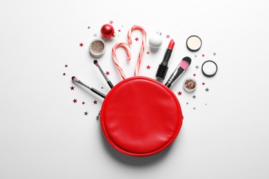 Flat lay composition with makeup products and Christmas decor on white background