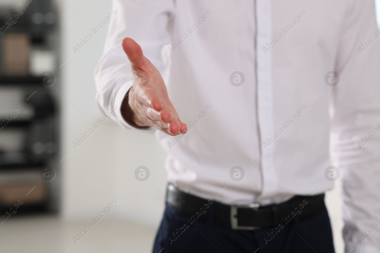 Photo of Man welcoming and offering handshake indoors, closeup