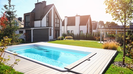 Photo of New modern house with backyard swimming pool on sunny day