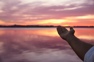 Photo of Man near river at sunset, closeup view with space for text. Nature healing power