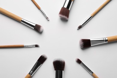 Photo of Frame of makeup brushes on white background, flat lay. Space for text