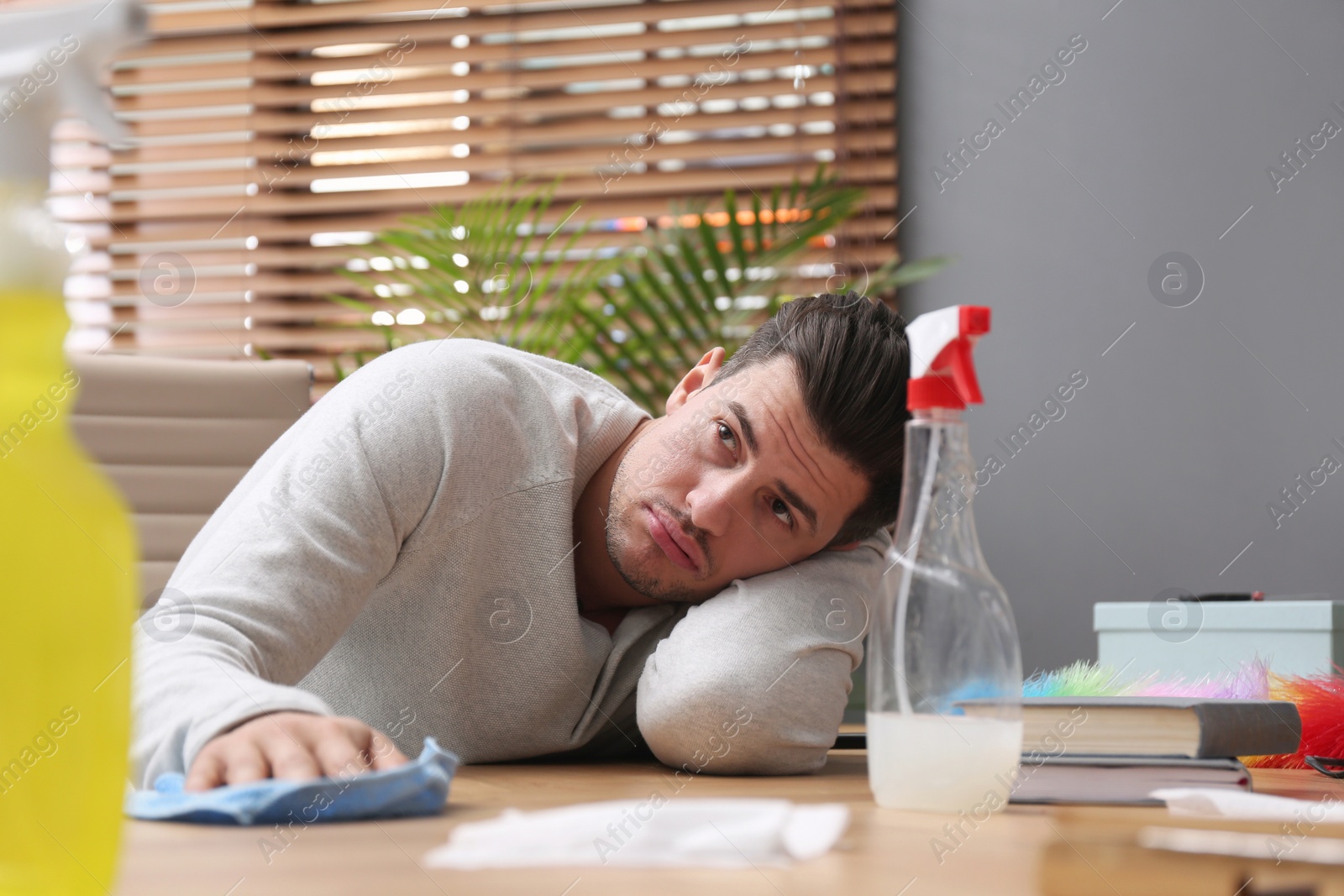 Photo of Lazy man procrastinating while cleaning at home