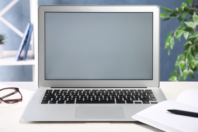 Photo of Modern laptop with blank screen on office table