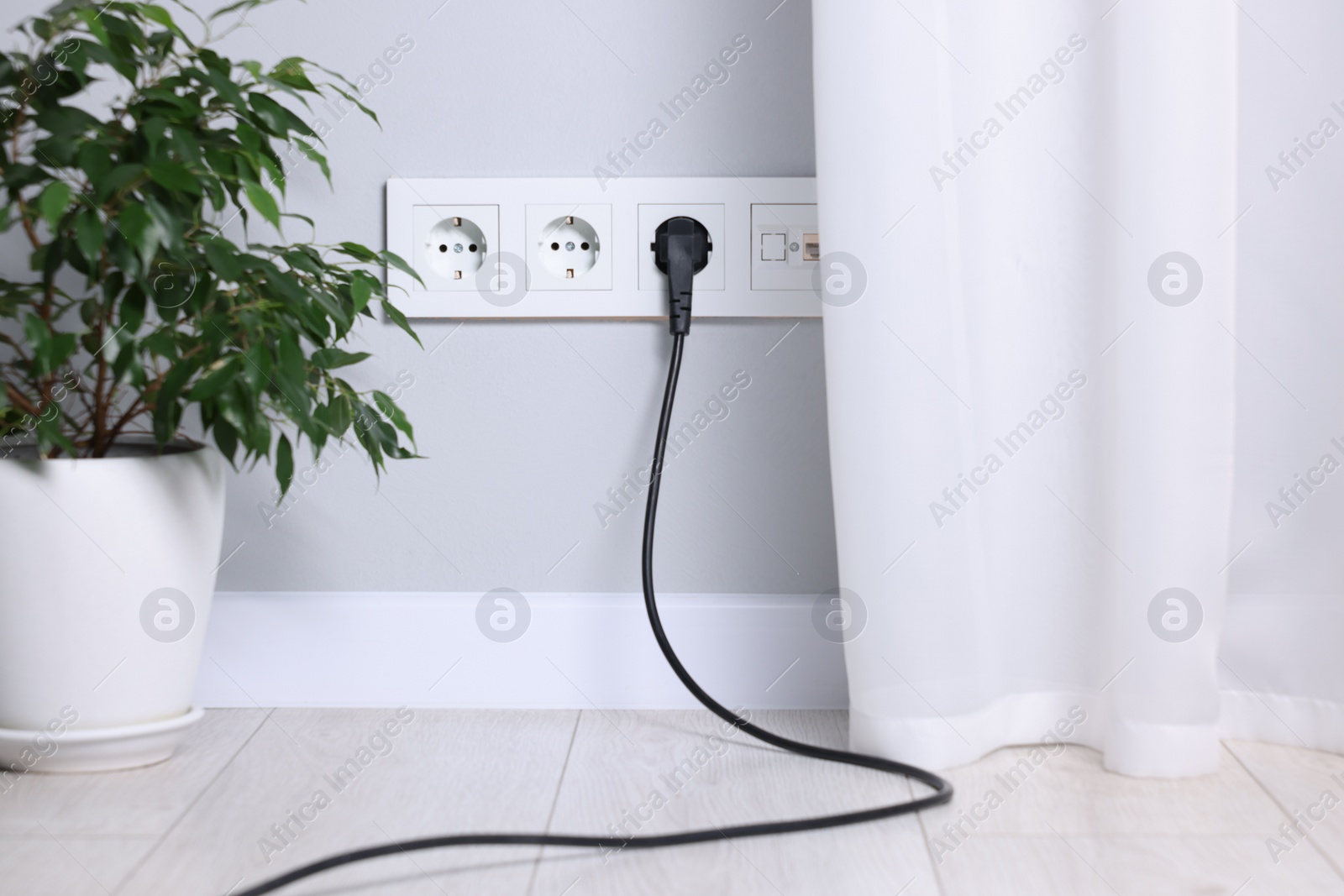 Photo of Power sockets and electric plug on grey wall