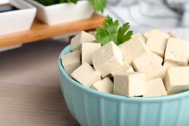 Photo of Delicious tofu with parsley in bowl on table, closeup