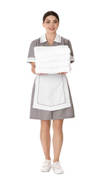 Young chambermaid holding stack of fresh towels on white background