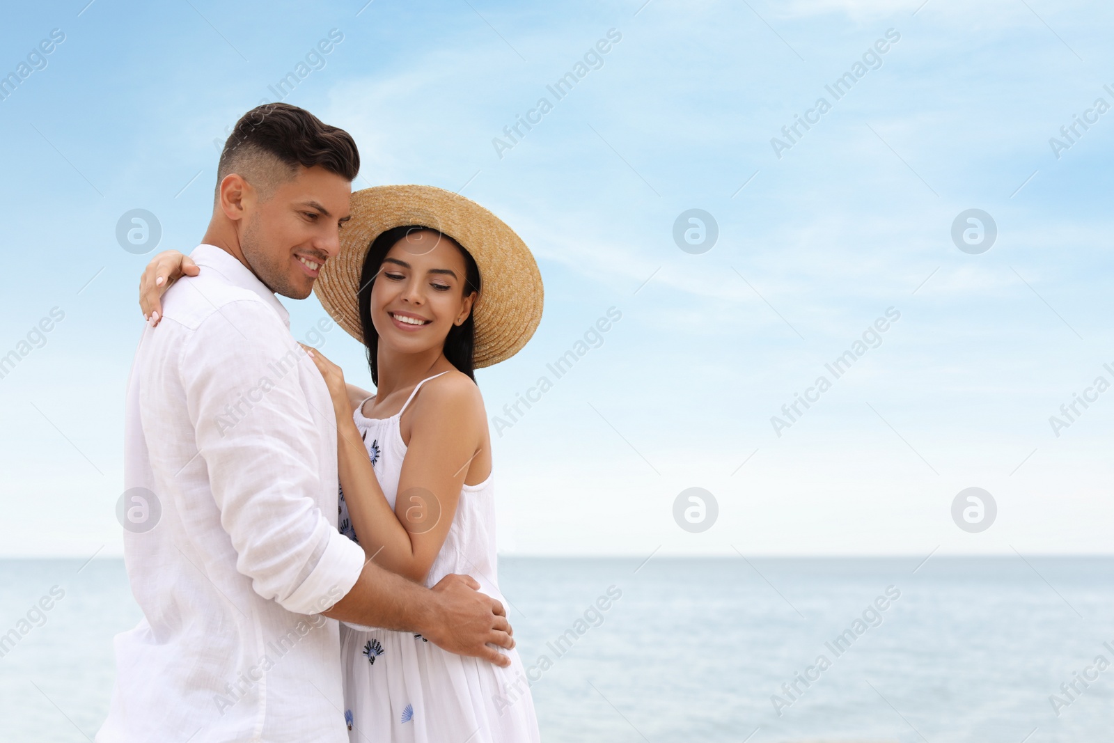 Photo of Lovely couple spending time together on beach near sea. Space for text