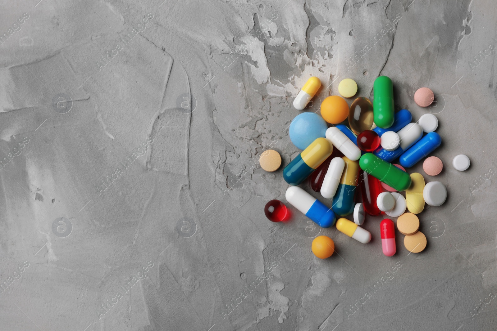 Photo of Heap of different pills on table, top view. Space for text