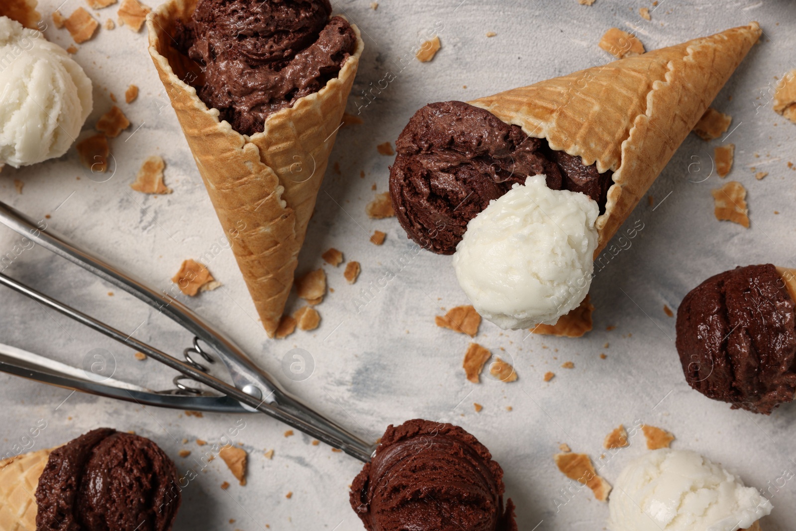 Photo of Composition with tasty ice cream scoops in waffle cones on light textured table, above view