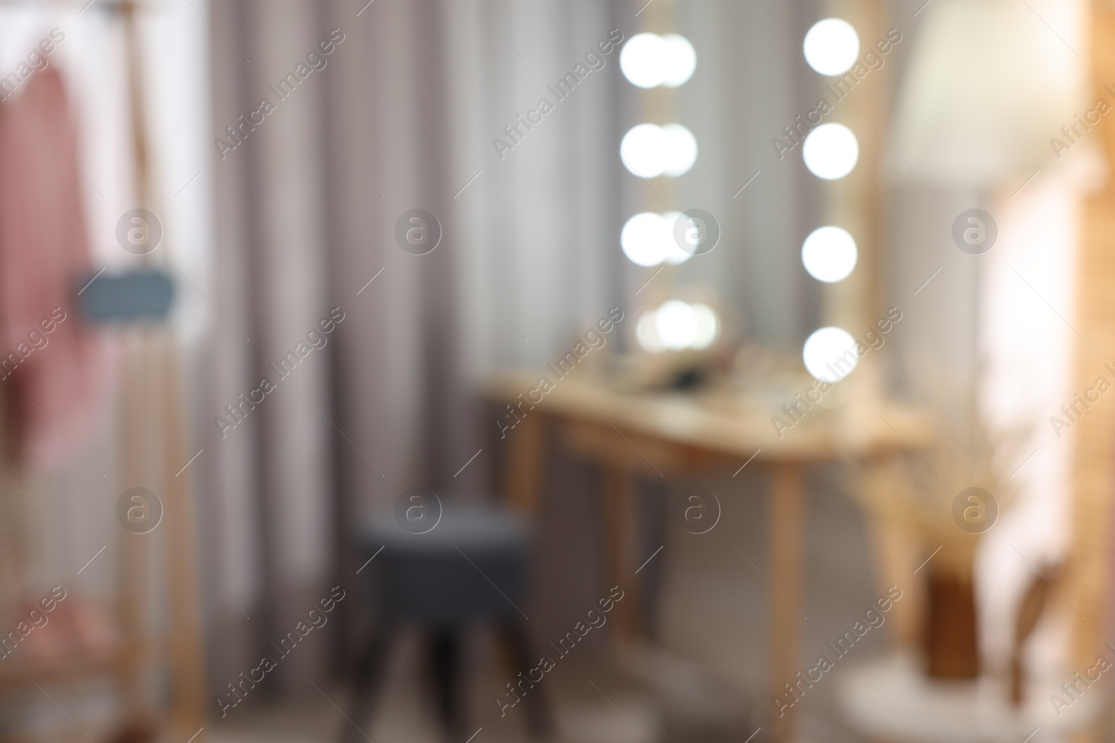 Photo of Blurred view of makeup room with stylish mirror, dressing table and chair