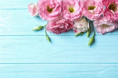 Photo of Flat lay composition with beautiful Eustoma flowers on wooden background