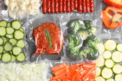 Photo of Many different food in vacuum packings on table, top view