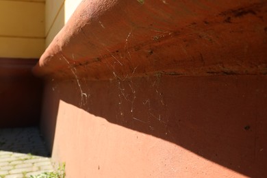 Photo of Cobweb on old building outdoors on sunny day