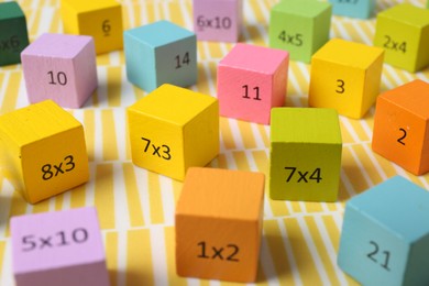 Colorful cubes with numbers and multiplications on yellow background