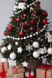 Photo of Christmas tree and gift boxes on light grey background