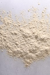 Photo of Pile of flour on light textured table, top view