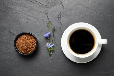 Cup of delicious chicory drink, granules and flowers on black table, flat lay