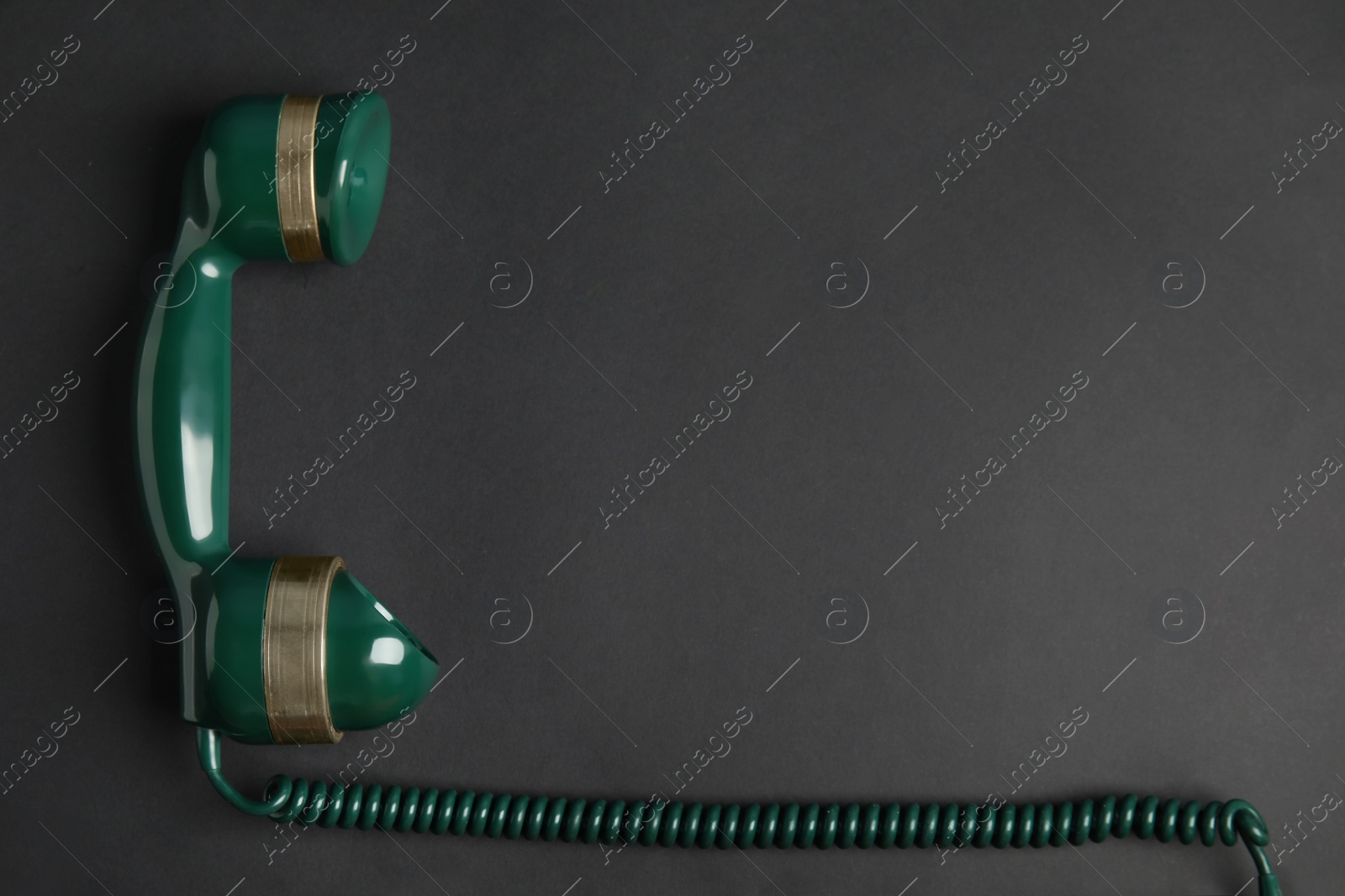 Photo of Handset of vintage green telephone on black background, top view. Space for text