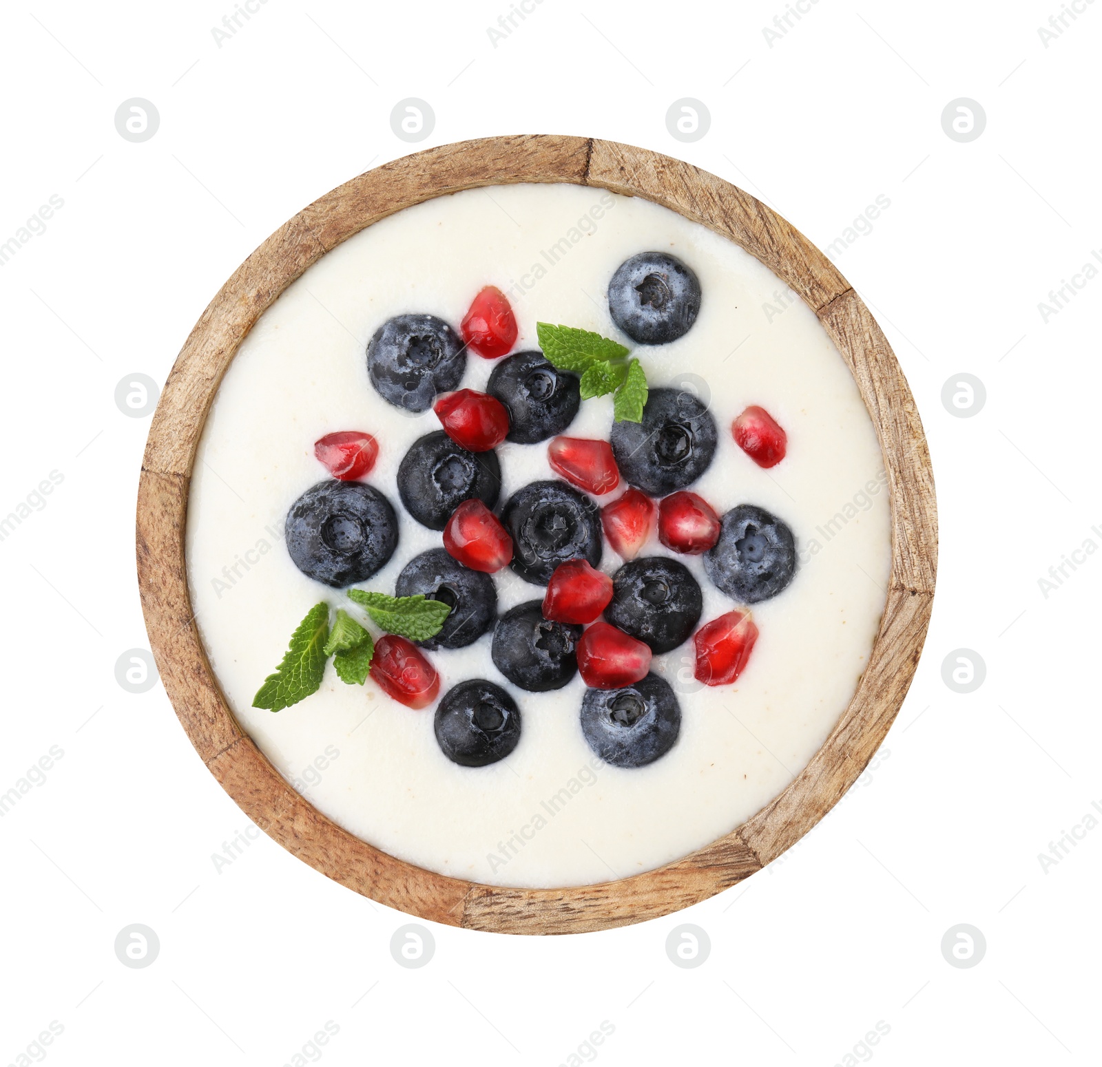 Photo of Bowl of delicious semolina pudding with blueberries, pomegranate and mint isolated on white, top view