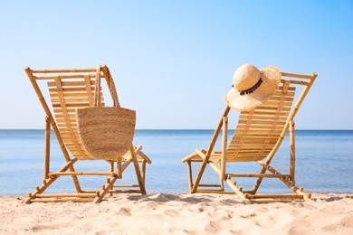 Photo of Wooden deck chairs on sandy beach near sea