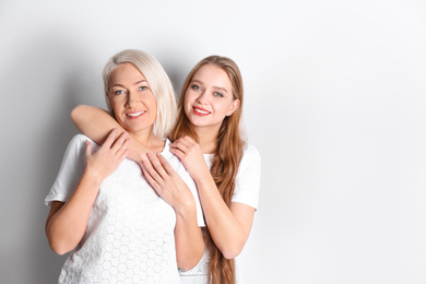 Photo of Mother and her adult daughter on white background. Space for text