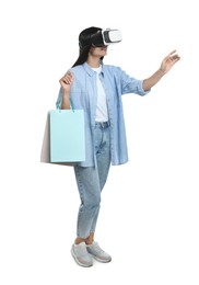 Photo of Woman with shopping bags using virtual reality headset on white background