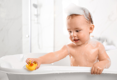 Cute little baby in bathtub at home