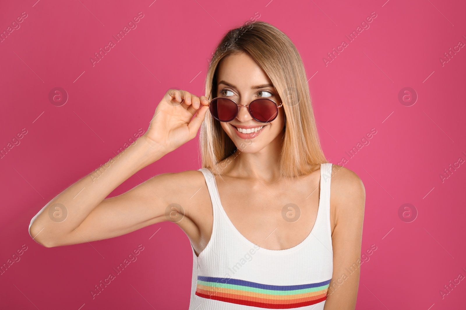 Photo of Beautiful woman in stylish sunglasses on pink background