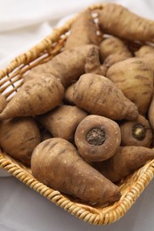 Tubers of turnip rooted chervil in wicker basket on table, closeup