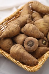 Photo of Tubers of turnip rooted chervil in wicker basket on table, closeup