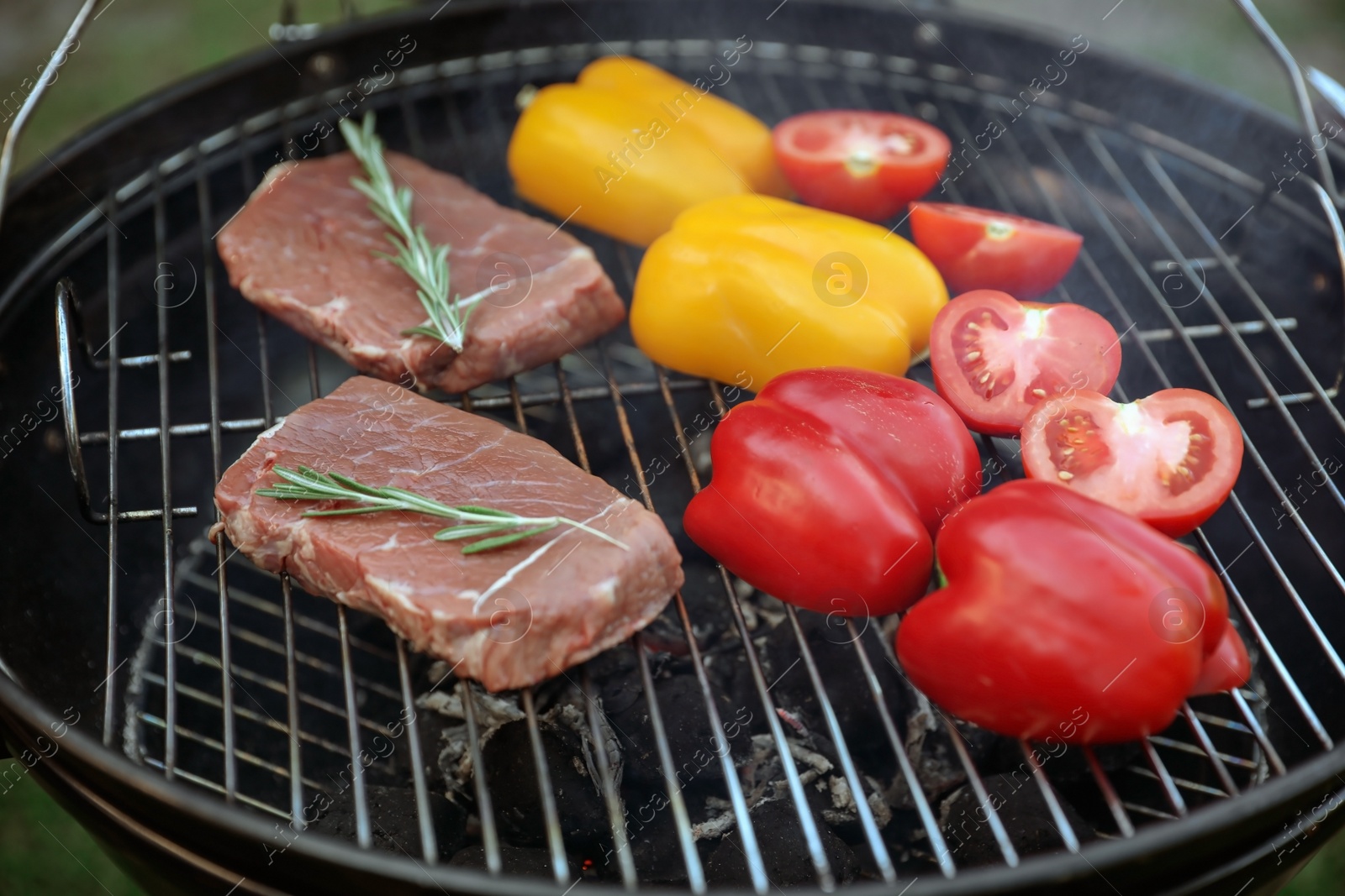 Photo of Fresh steaks and vegetables on barbecue grill, closeup