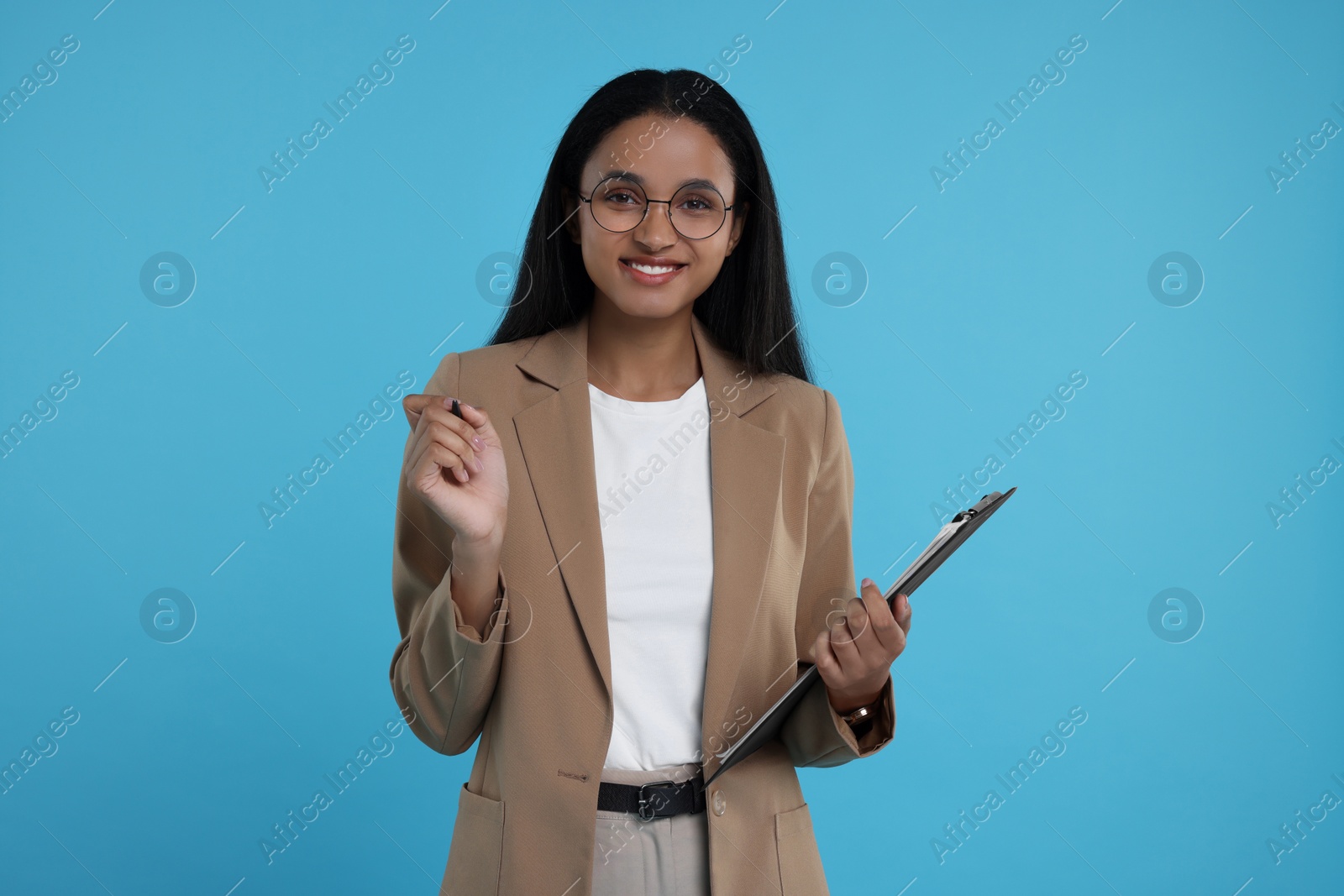 Photo of Beautiful secretary with clipboard and pen on light blue background