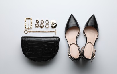 Photo of Stylish woman's bag, shoes and bijouterie on light background, flat lay