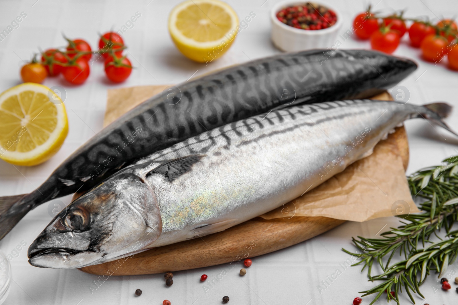 Photo of Raw mackerel and rosemary on white table