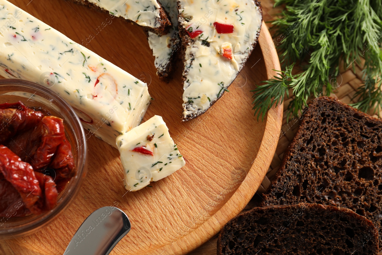 Photo of Tasty butter, dill, chili pepper and rye bread on table, top view