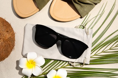 Photo of Flat lay composition with stylish sunglasses and cloth bag on sand