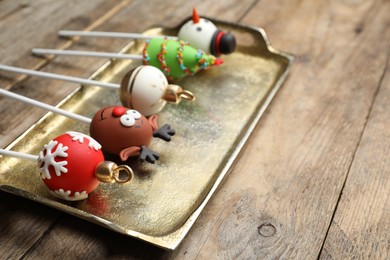 Photo of Delicious Christmas themed cake pops on wooden table, closeup