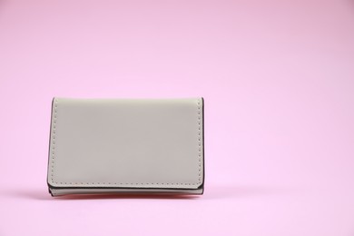 Stylish leather purse on pink background, space for text