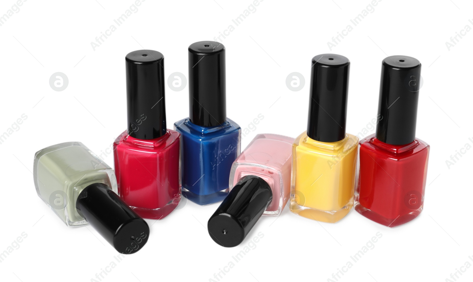 Photo of Bright nail polishes in bottles isolated on white