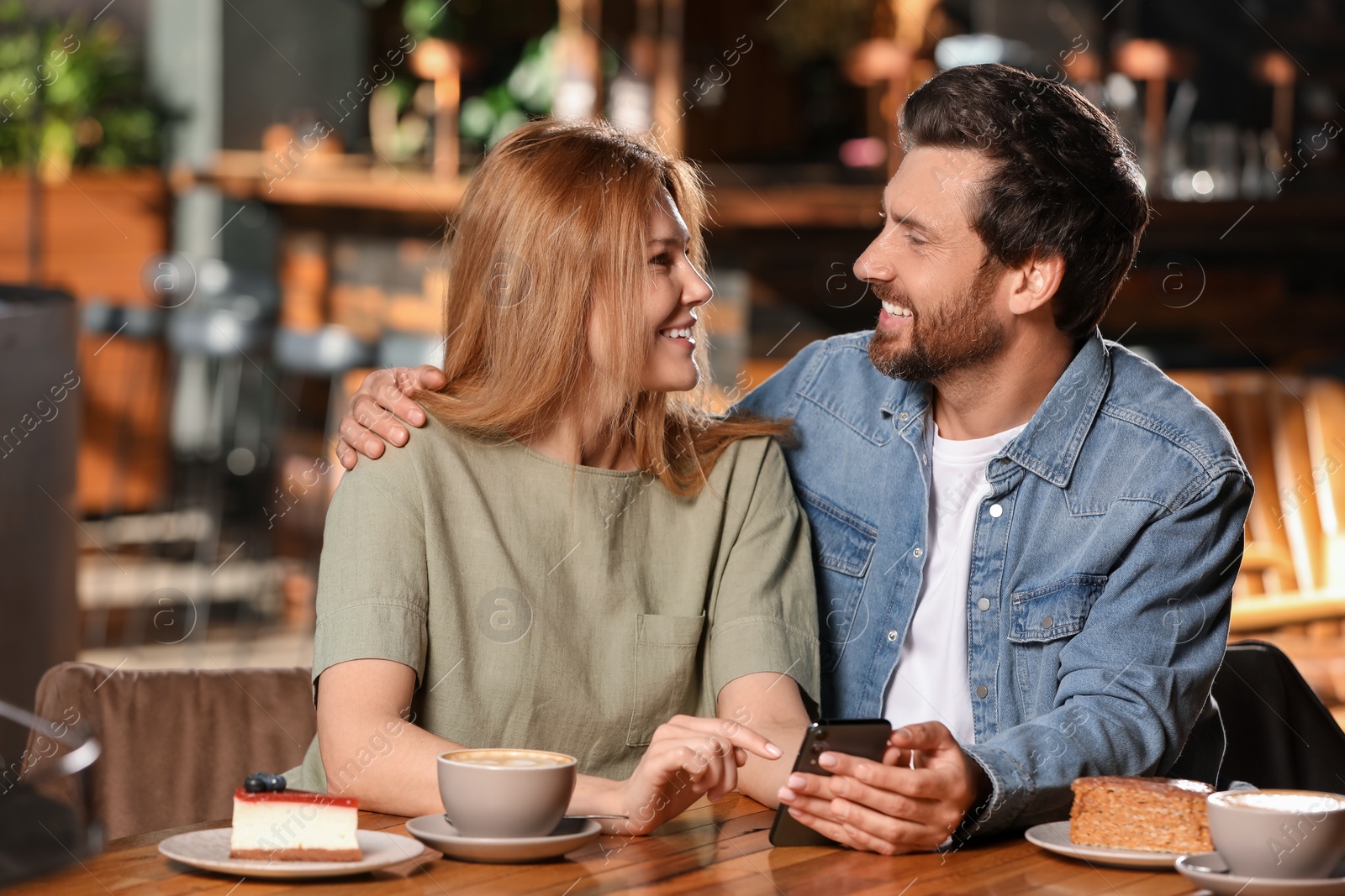 Photo of Romantic date. Lovely couple spending time together in cafe