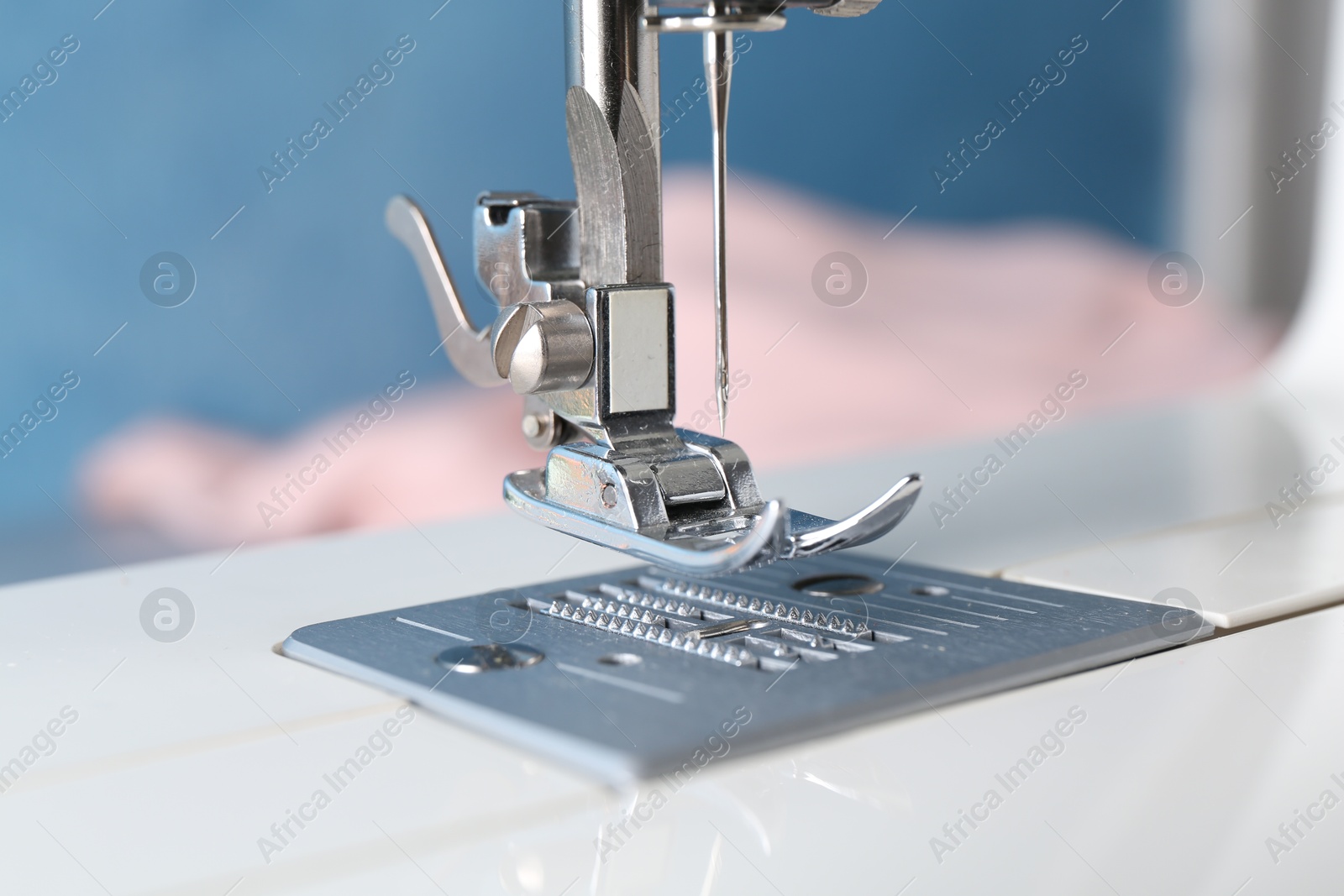 Photo of White sewing machine on light background, closeup