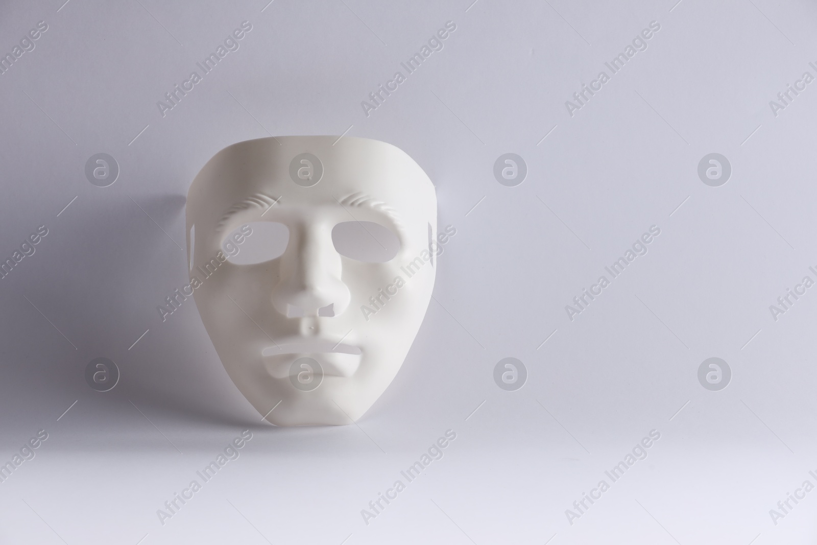 Photo of Plastic face mask on white background, space for text. Theatrical performance