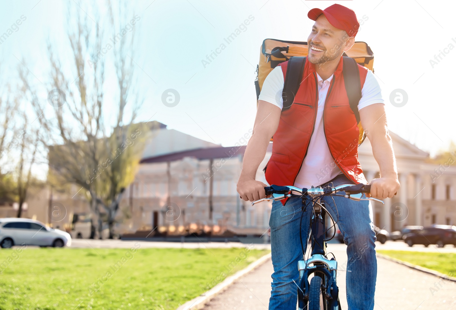 Photo of Male courier on bicycle delivering food in city